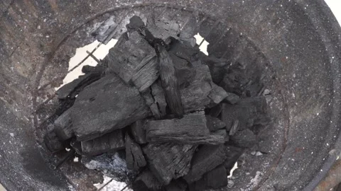 Closeup of several coals on a grill dripping smoke from the fire inside and Stock Footage 155806845