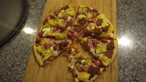 Closeup of several hands grabbing a triangular slice of a homemade pizza on a 스톡 동영상 193033053