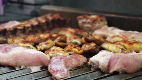 Closeup of several raw meats on the grill and in the background other meats Stock Footage 178460782