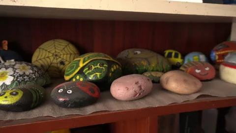 Closeup of several rocks painted in the shape of a turtle, ladybug and potatoes Stock Footage 140395242