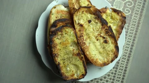 Closeup of several slightly burnt garlic bread viewed from above Stock Footage 140131970