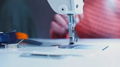 Closeup of a sewing machine boot. A seamstress woman is threading a metal part. Stock-Footage 128164966