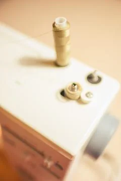 Closeup sewing machine with thread spool on rod and on winder Stock Photos