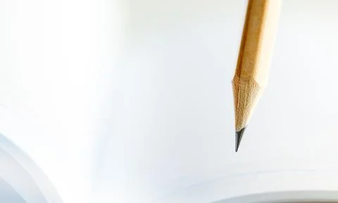 Closeup of sharp graphite pencil on white paper of notebook.  Concept of The Stock Photos