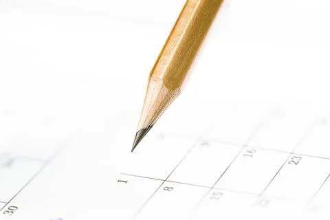 Closeup of sharp graphite pencil on white paper of calendar.  Concept of The Stock Photos