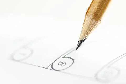 Closeup of sharp graphite pencil on white paper of calendar.  Concept of Inte Stock Photos