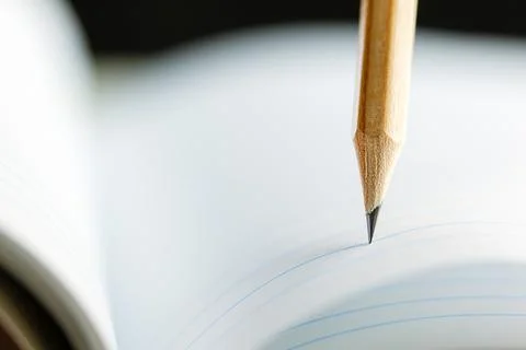 Closeup of sharp graphite pencil on white paper of notebook.  Concept of Th.. Stock Photos