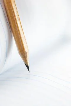 Closeup of sharp graphite pencil on white paper of notebook.  Concept of Th.. Stock Photos