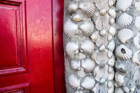 Closeup of shells wall and red door 스톡 사진