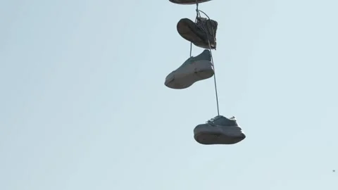 Closeup of Shoes on String Over A Street Stock Footage 307932352