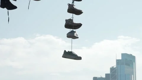 Closeup of Shoes on String Over A Street Stock Footage 307932355
