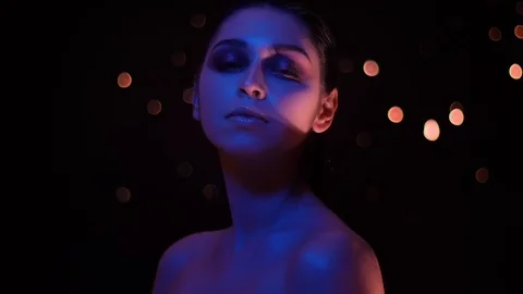 Closeup shoot of pretty female with glitter makeup with violet neon light and Stock-Footage 106934694