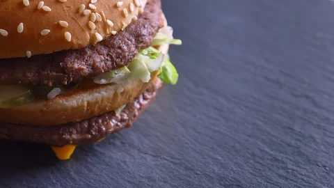 Closeup shoot of tasty souble cheeseburger with two patties and cheese spinning Video stock 101770733