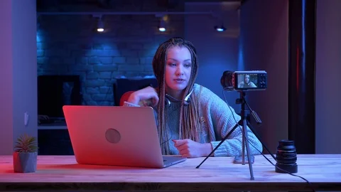 Closeup shoot of young attractive female blogger with dreadlocks in headphones Video stock 106979893