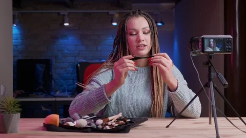 Closeup shoot of young attractive female blogger with dreadlocks streaming live Video stock 106989277