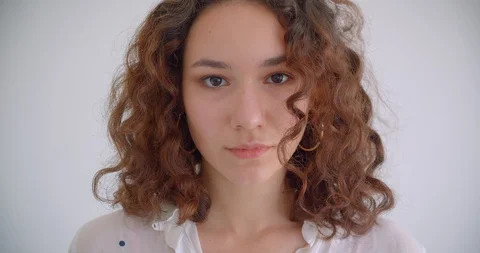 Closeup shoot of young pretty long haired curly caucasian female looking at Video stock 109800048