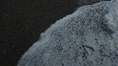 Closeup of shoreline with rhythmic surf and textured backwash 動画素材 335950530