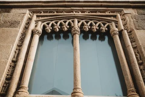 A closeup shot of an ancient gothic window with old caving patterns in Lamego Stock Photos
