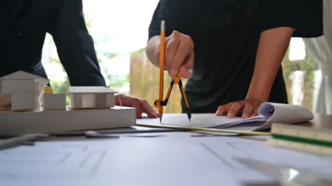 Closeup shot of architects man using compass to measuring scale on a blueprint Stock Footage 251560537