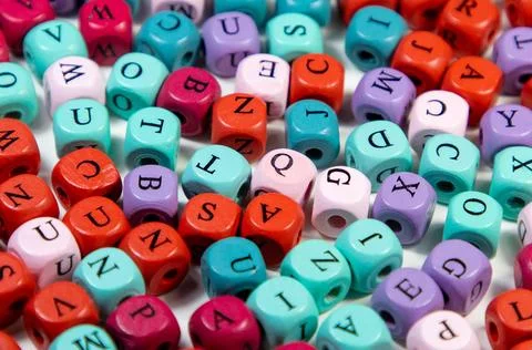 Closeup shot of an array of colorful cubic beads with letters 스톡 사진