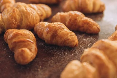 Closeup shot of an array of freshly baked, buttery croissants on a wooden table Fotos de archivo