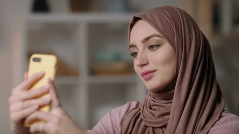 Closeup shot of attractive middle eastern girl wearing hijab scarf taking Stock Footage 127552315