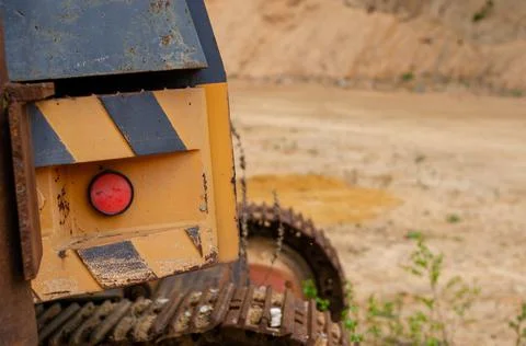 A closeup shot of a back red button of a yellow striped trenching machine in  Stock Photos