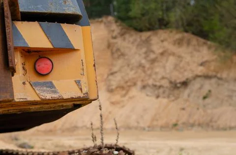 A closeup shot of a back red button of a yellow striped trenching machine in  Stock Photos