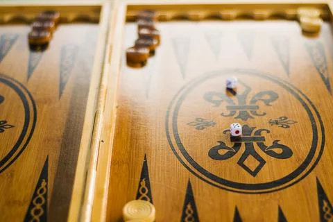 A closeup shot of a backgammon dice in the middle of the game on a blurred ba 写真素材