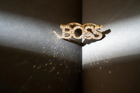 A closeup shot of a beautiful gold ring Boss on a black background, book Stock Photos