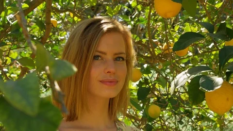 Closeup Shot of Blonde Model Reaching and Smelling the Lemon from the Tree 스톡 동영상 116562366