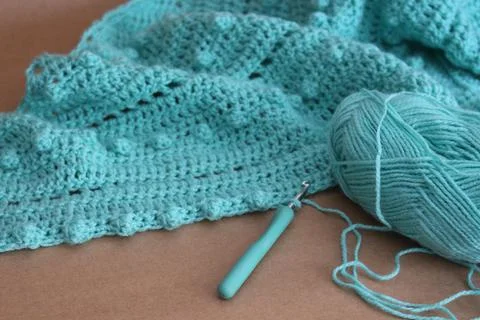 Closeup shot of a blue string in a crochet pattern and tools Stock Photos