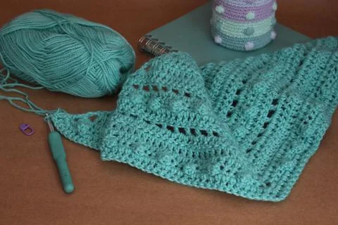 Closeup shot of a blue string in a crochet pattern and tools Stock Photos
