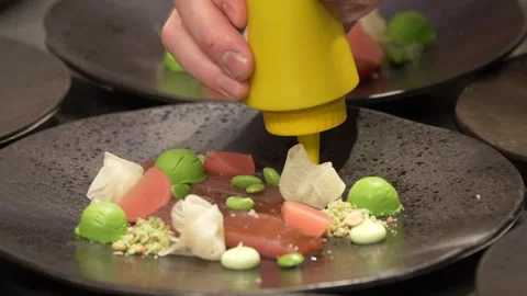 Closeup shot of the chef hands garnishing the salmon plate with mayo sauce in Stock Footage 265945368