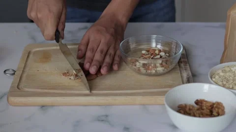 Closeup shot of a chef slicing almonds on a kitchen board to make cookies Stock Footage 139259980
