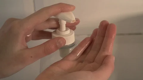 Closeup shot of a child using a soap dispenser and cleaning her hands for Stock Footage 126801611