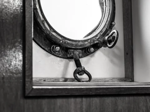 Closeup shot of a circular window of a ship with thick metal frames Stock Photos