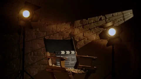 Closeup shot of clapperboard standing on director's chair, surrounded by popcorn Stock Footage 250880249