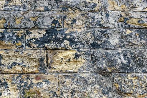 Closeup shot of colorful bumpy bricks with stains forming a wall Stock Photos