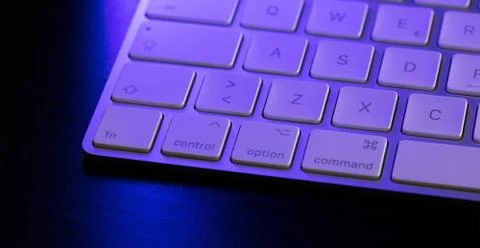 Closeup shot of a computer keyword  with a blue light on it Stock Photos