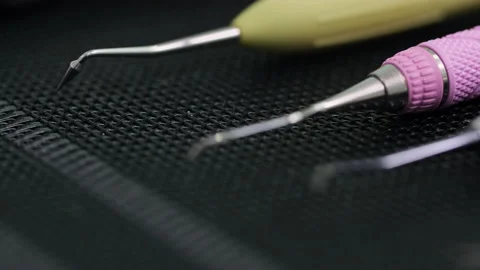 Closeup shot of Dentist tools on black mat. Racking focus to the edge of the Stock Footage 131483511