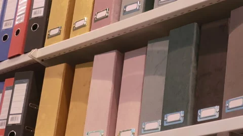 Closeup shot of different colors of storage folders for documents in shelves. Stock Footage 156375536
