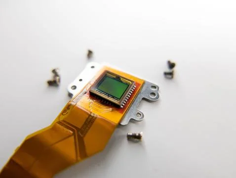 Closeup shot of a digital camera sensor and screws around it on a table Stock Photos
