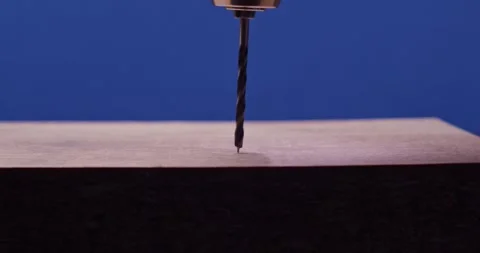 A CloseUp Shot of a Drill Bit Readying to Penetrate a Wood Surface with Stock Footage 297953117
