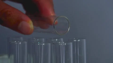 Closeup shot of dropping liquid/Orange liquid into test tube. Stock Footage 323781629