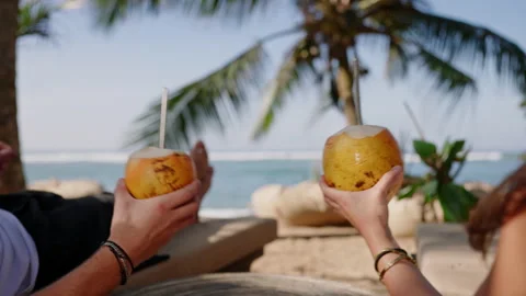 Closeup shot of fresh king coconuts with exotic background. Tourists holding two Video stock 234155904