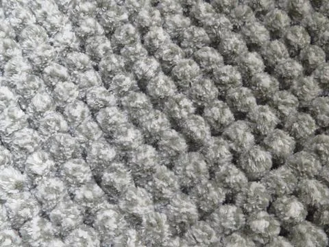 Closeup shot of a gray fluffy bumpy patterned carpet texture 스톡 사진