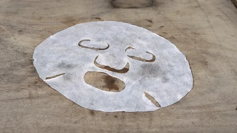 Closeup shot of group of snails on a white mask for the face shot on a wooden Stock Footage 117560676