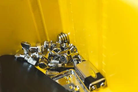 Closeup shot of guitar string locks on the yellow background, guitars pieces Foto stock
