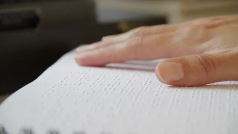 Closeup shot hand reading a page in braille Stock Footage 139099264